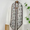Detailed shot of a black and white floral print twilly scarf, elegant neck and hair accessory. - Flower-1