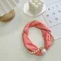 Gedetailleerd overzicht van de elegante roze zijden sjaalketting verweven met parels en magneet. - Ketting Zonder Parel / Roze