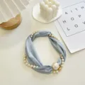 Delicate lichtblauwe stoffen bandketting met kunstparels en een handige magneetsluiting. - Ketting Zonder Parel / Lichtblauw