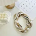 Detailed shot of floral print silk scarf featuring elegant faux pearls and magnetic clasp. - Pearl Scarf-7