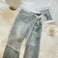 Vista di dettaglio della gonna a portafoglio in rete di pizzo abbinata a jeans azzurri. - Pantaloni e gonne / Mezza Gonna 1