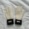 Close-up view of winter knitted gloves featuring black plush cuffs and detailed knit texture. - One Size / Off White