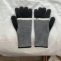 Detailed view of colorblock knit gloves with ribbed cuffs, warm winter accessories. - One Size / Black and Gray