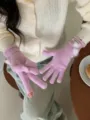Gedetailleerde close-up van gezellige roze gebreide handschoenen met schattige pompons. - Roze
