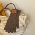 Cozy brown knit long gloves in a lifestyle bag setting, perfect for winter warmth and daily style. - Momi Color