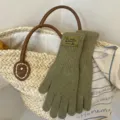 Detailed view of the cozy green knit five-finger gloves featuring a cute woven brand label. - Grass Green
