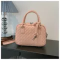 Pink woven leather detail view, featuring classic intrecciato style and delicate metal zippers. - Pink