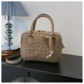 Detailed shot of a chic woven top handle shoulder crossbody bag in taupe chic daily style. - Khaki