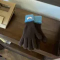 Closeup of women's color-block knit gloves in brown and blue with ribbed cuffs and tag. - One Size / Coffee Blue