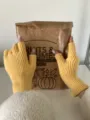 Detalle de guantes de punto sin dedos amarillos con textura acanalada y diseño abierto. - 21 cm x 8 cm / Amarillo