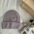 Gros plan détaillé d'un bonnet en tricot mauve clair confortable, texture côtelée en arrière-plan - Taille unique (54-60 cm) / Violet
