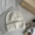 Vue détaillée du bonnet tricoté blanc pour femmes, bord rabattu classique couleur unie bonnet chaud. - Taille unique (54-60 cm) / Blanc