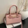 Pink woven handbag with top handle and gold lock detail, stylish chic cross body bag. - Pink