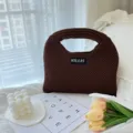 Braune Strick-Handtasche im Detail, zeigt die weiche Textur und das individuelle Etikett. - S / Braun
