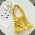 Primo piano dettagliato della borsa a rete lavorata all'uncinetto gialla con trama e lavorazione. - 21cmX6cmX31cm / Giallo