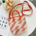 Knitted geometric tote bag with red handles and shoulder strap, stylish daily detail view. - Orange