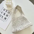 Vista dettagliata della borsa a mano cava in macramè beige fatta a mano con elegante allestimento. - 21cmX6cmX31cm / Bianco