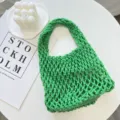 Primer plano del bolso de red tejido verde, detalle de bolso de cordón de algodón en escritorio. - 21cmX6cmX31cm / Verde