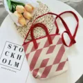 Detailed view of red white knitted tote bag detail scene with elegant flowers and card decor. - Red