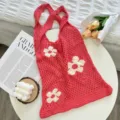 Detailed shot of red hollow knitted floral tote bag with white flower motif on table. - Rose Red