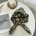Vue détaillée d'un élégant carré en coton vert à fleurs, idéal pour chemises ou foulard. - Carré Vert