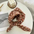 Vue détaillée d'un carré de coton à motif floral rétro, joliment disposé sur une table. - Rouge Orange Carré