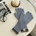 Vista detallada de guantes táctiles de punto azul grisáceo en una mesa blanca minimalista. - Talla Única (28cmX7cm) / Azul cielo