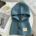 Nahaufnahme des blauen gestrickten Kapuzenschals mit Knöpfen, kuscheliger wärmender Kragen. - Himmelblau