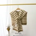 Detailed view of the striped knitted shawl, showcasing the tie closure and soft texture. - One Size / Khaki