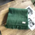 Grüner Strick-Winterschal Detailansicht mit Fransen und Etikett, weiches warmes Zubehör. - 160 cm x 25 cm / Dunkelgrün