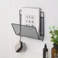 Wall-mounted metal wire magazine rack, black mesh storage shelf for home office wall decor. - Black