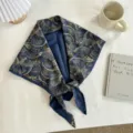 Detailed view of a vintage blue paisley triangle silk scarf styled with clean lifestyle props. - 140*70cm / Blue