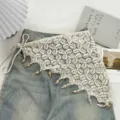 Detailansicht des ethnischen Häkel-Dreieck-Wickelrocks mit Muschelfransen und Perlenbändern. - Einheitsgröße / Dreieckiger Quastenstil / Beige
