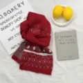 Detailed view of red knitted Christmas tree scarf with wool blend material for winter season. - Red