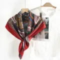 Close-up detail of vintage style large square silk scarf with retro print and elegant red border. - Red