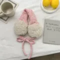 Detailaufnahme von Plüsch-Ohrwärmern aus Strick mit flauschiger Lammwollpolsterung und Bindebändern. - Einheitsgröße / Rosa
