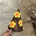 Gros plan du chapeau de fête en feutre marron avec de jolies fleurs jaunes, idéal pour les bébés. - Style Petite Fleur