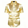 Détail de chemise à manches courtes en satin doré avec empiècement de sequins et boutons noirs. - Or