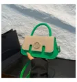 Dettaglio della piccola borsa a tracolla verde con patta in paglia e logo M in metallo. - Verde