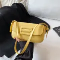 Modische gelbe Umhängetasche mit elegantem Klappdeckel und stylischem Schnallendetail neu. - Gelb