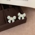 Mint green bowknot stud earrings featuring sweet rhinestone details and white rose flower charms. - Crystal Flower (VX2) / Mint Green