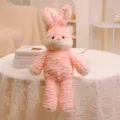 Primer plano de un tierno conejito de peluche rosa con textura de volantes y decoración de habitación. - Conejo