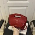 Red patent leather underarm bag with cut-out handle and adjustable shoulder strap for women. - Red