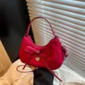 Rode suède schoudertas met elegante strik en metalen hartje hanger voor dagelijks stijlvol gebruik. - Rood