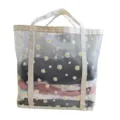 Vista detallada de la bolsa de malla transparente con estampado de margaritas y asas resistentes. - Girasol / Extragrande / Beige