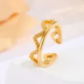 Primo piano di un elegante anello aperto dorato con perline e dettagli intagliati a cuore. - Stile Taglio Cuore (JZR944-E) / Oro