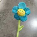 Primo piano dettagliato del simpatico peluche fiore smiley blu con petali morbidi e stelo. - Blu Oro / 30cm