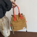Sac seau casual marron avec poignées orange vives et cordon de serrage élégant. - Orange