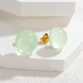 Detailed view of sweet candy color round stud earrings with gold tone backing and clear design. - Green