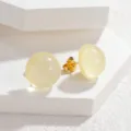 Close-up detail of sweet candy color round stud earrings, minimalist geometric design for women. - Yellow